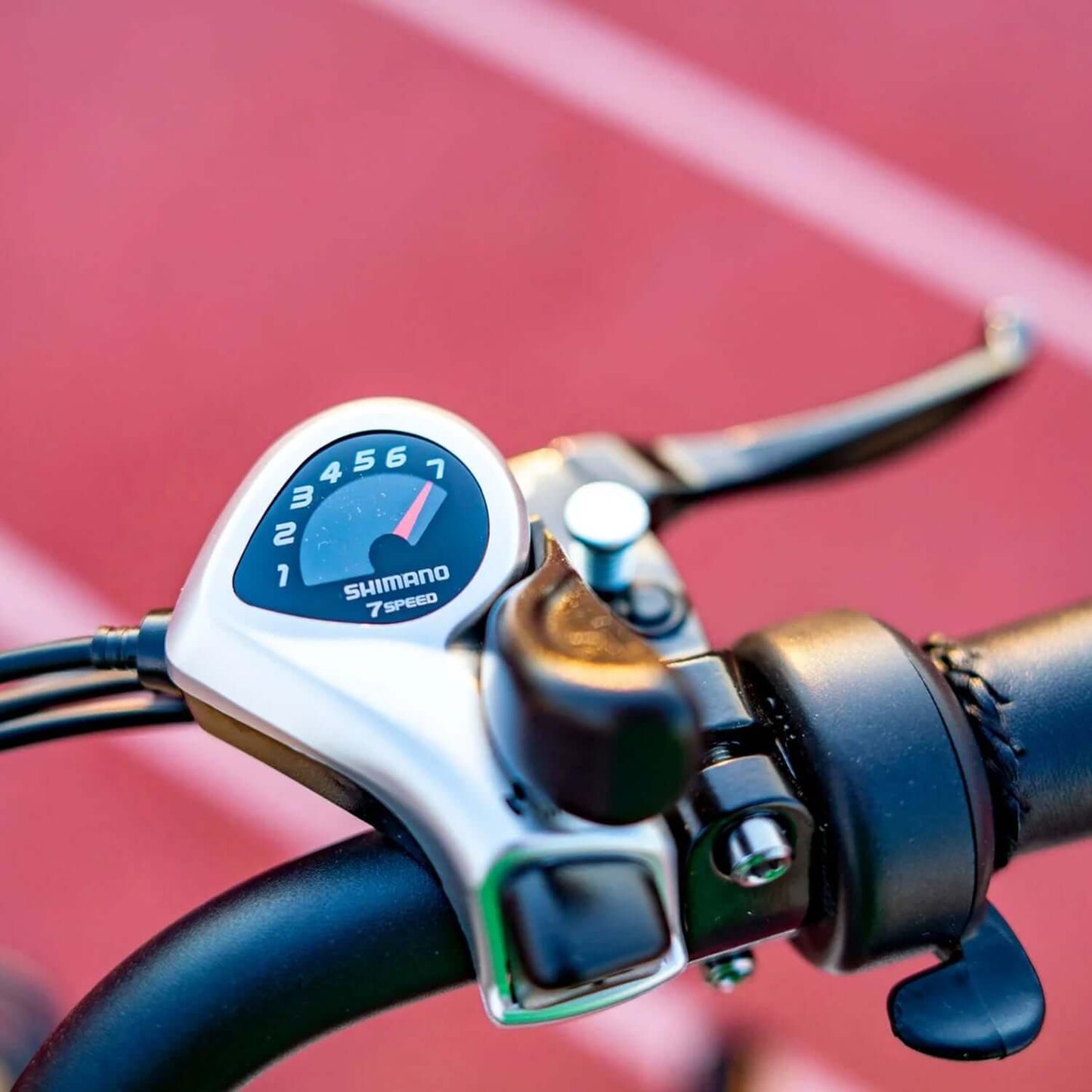 Close-up of Shimano 7-speed gear shift on an electric trike handlebar, showcasing precise speed control.