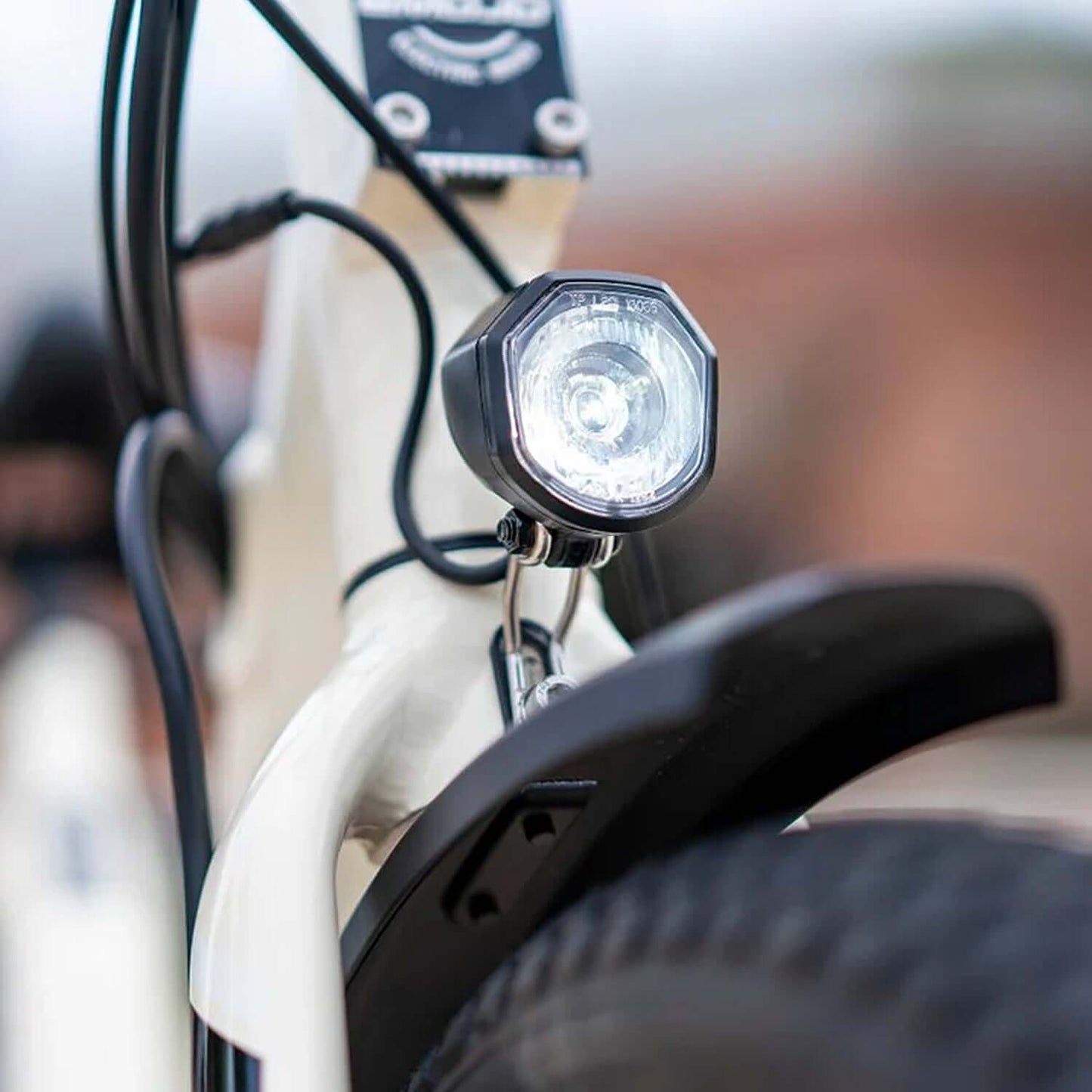 Close-up of the front light on an Emojo Bull 48V 500W Step-Thru Electric Trike, showcasing design and functionality.