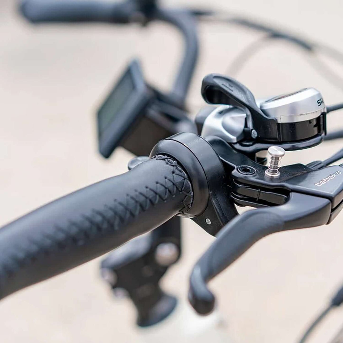 Close-up view of Emojo Bull electric trike handlebars, featuring grips and gear shifters.