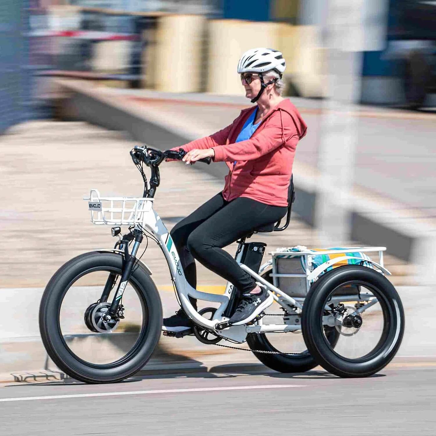 Woman riding the Emojo Caddy PRO 48V 500W fat tire step-thru electric trike on a sunny day.