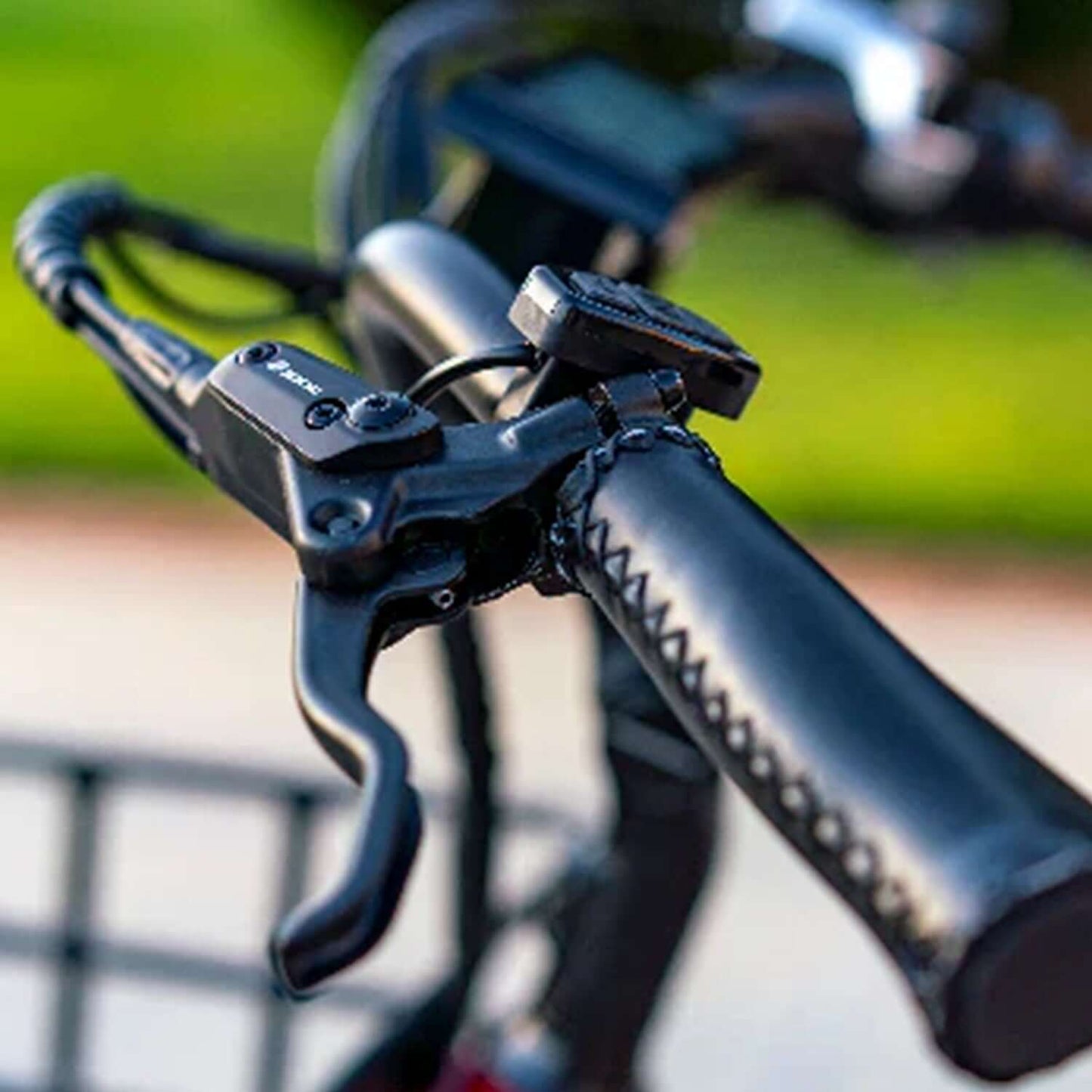 Close-up of the handlebars with brakes of the Emojo Caddy PRO Electric Trike, showcasing the ergonomic design and controls.