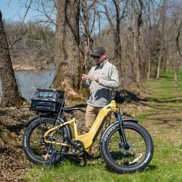 Person with a yellow electric bike in a forest setting