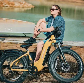 Person sitting on a yellow electric bike by a lake