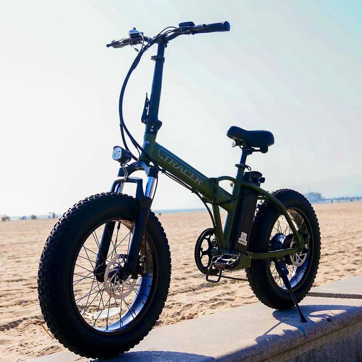 Tracer Coyote foldable electric bike with fat tires on a beach, showcasing durability and style.