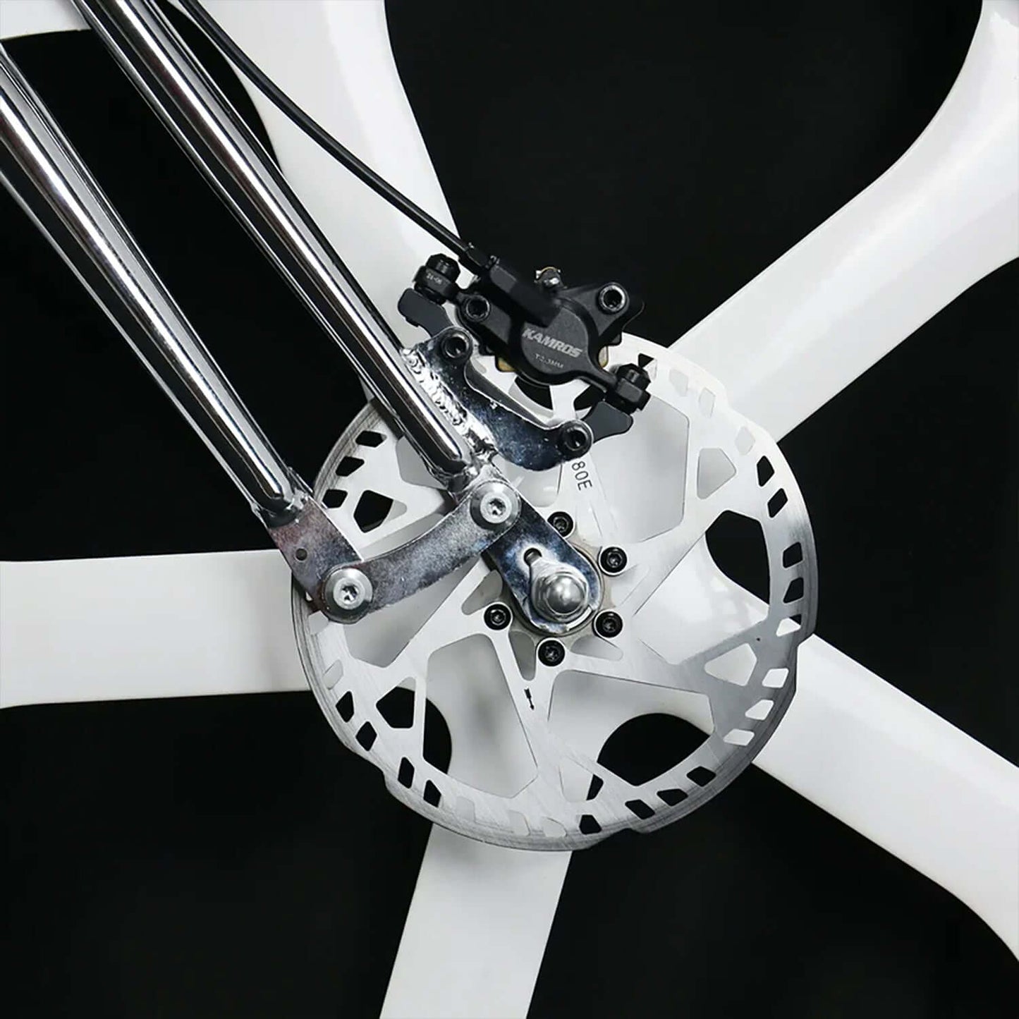 Close-up of a hydraulic disc brake system on a white bike wheel, showcasing the rotor and caliper.