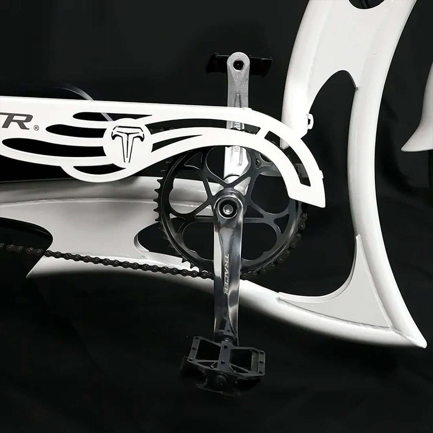 Close-up of the Tracer Raptor Pro DS Stretch Cruiser Electric Bike's pedal and crankset design on a sleek white frame.