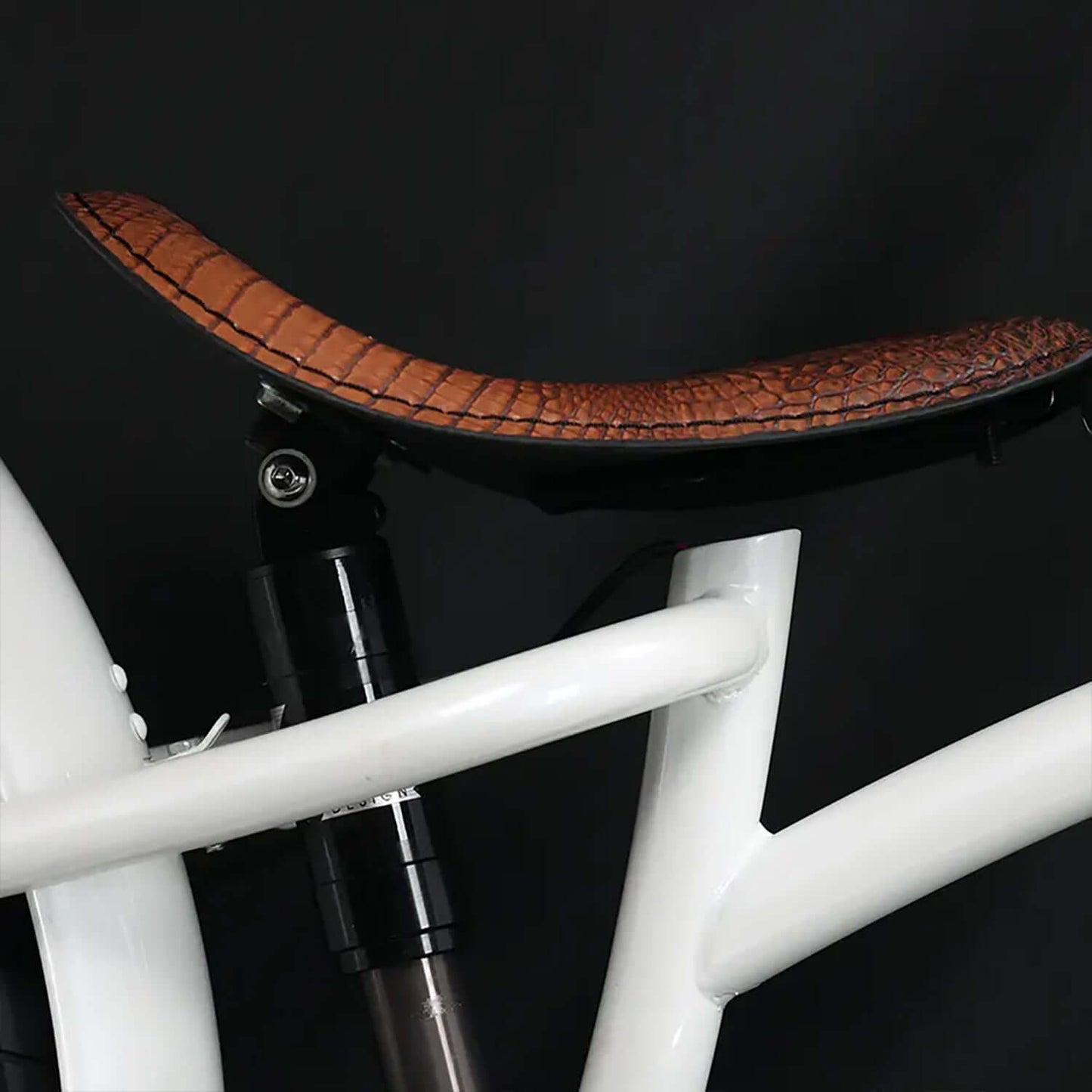 Close-up of the Raptor Pro DS electric bike seat featuring a stylish brown crocodile-patterned design.