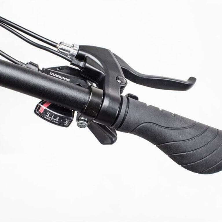 Close-up of the Shimano brake and gear system on a fat tire electric bike handlebar.