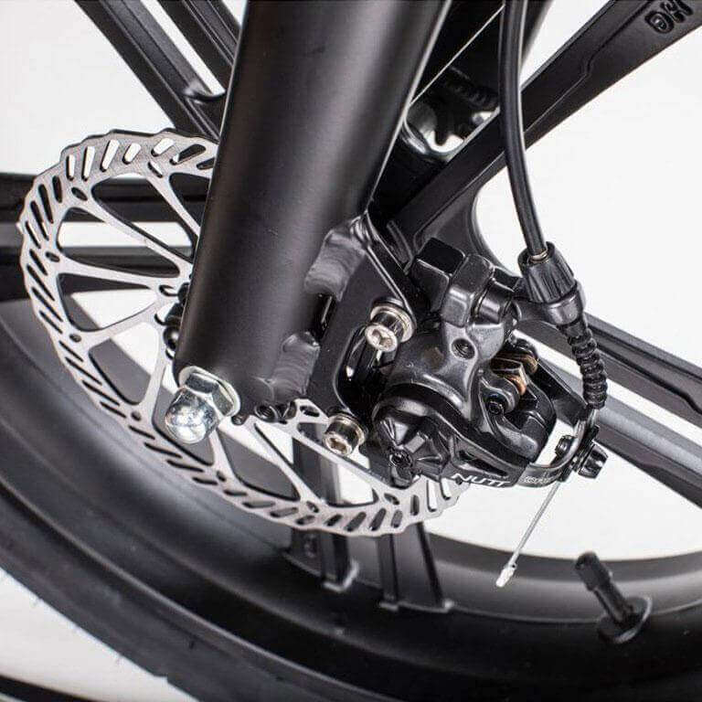 Close-up view of the brake system on the Qualisports Beluga electricians bike, highlighting the disc brake and components.
