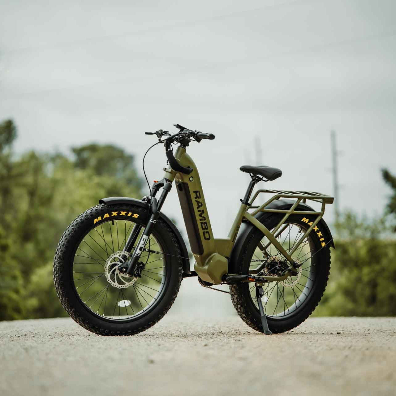 Green electric bike on a road with trees in the background