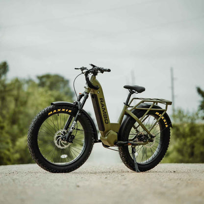 Green electric bike on a road with trees in the background