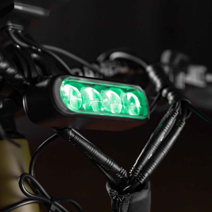 Green LED light attached to a bike handlebar with keys hanging nearby.