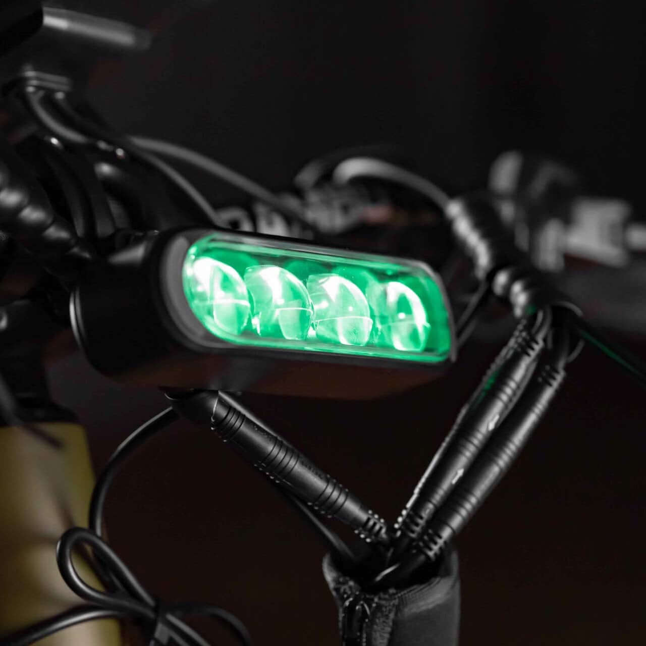 Green LED light attached to a bike handlebar with keys hanging nearby.