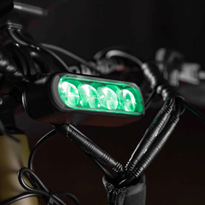Green LED light attached to a bike handlebar with keys hanging nearby.
