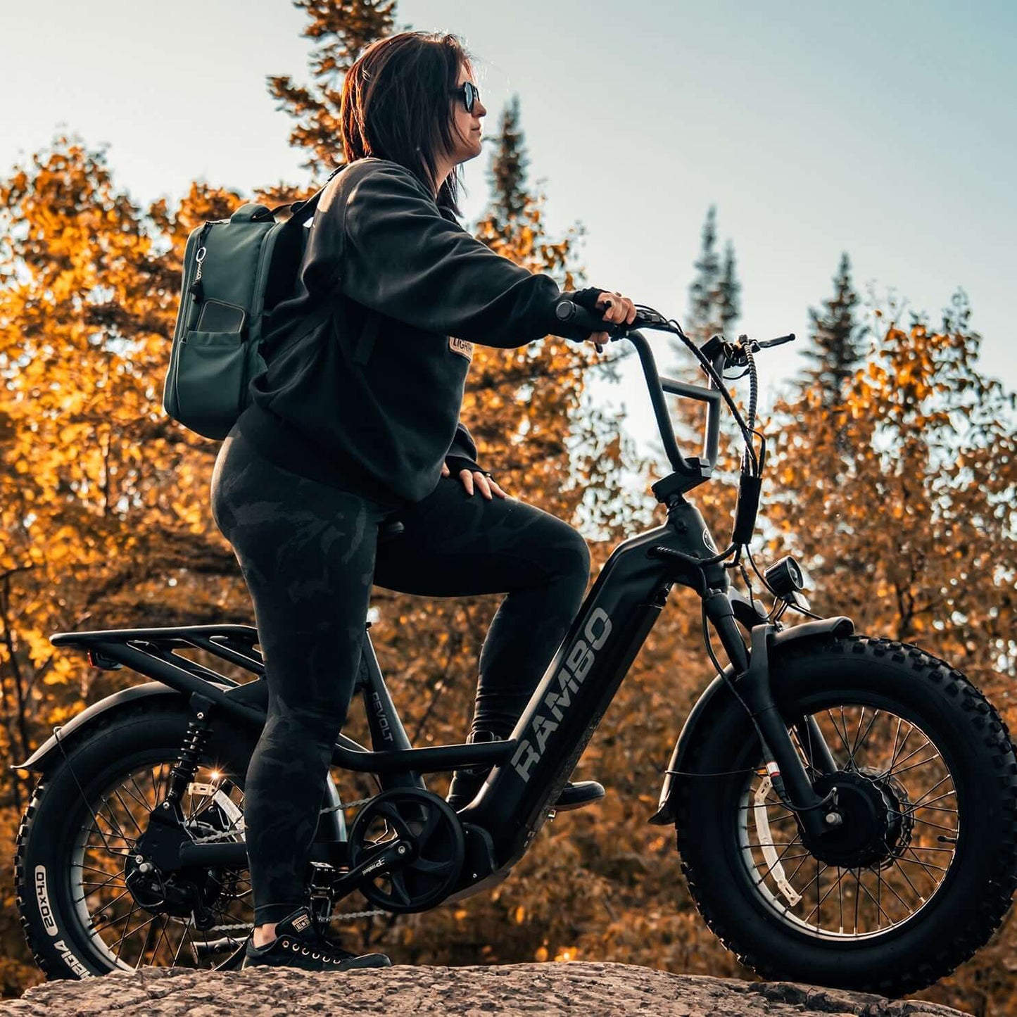 Person riding a electric bike in a forest with autumn foliage